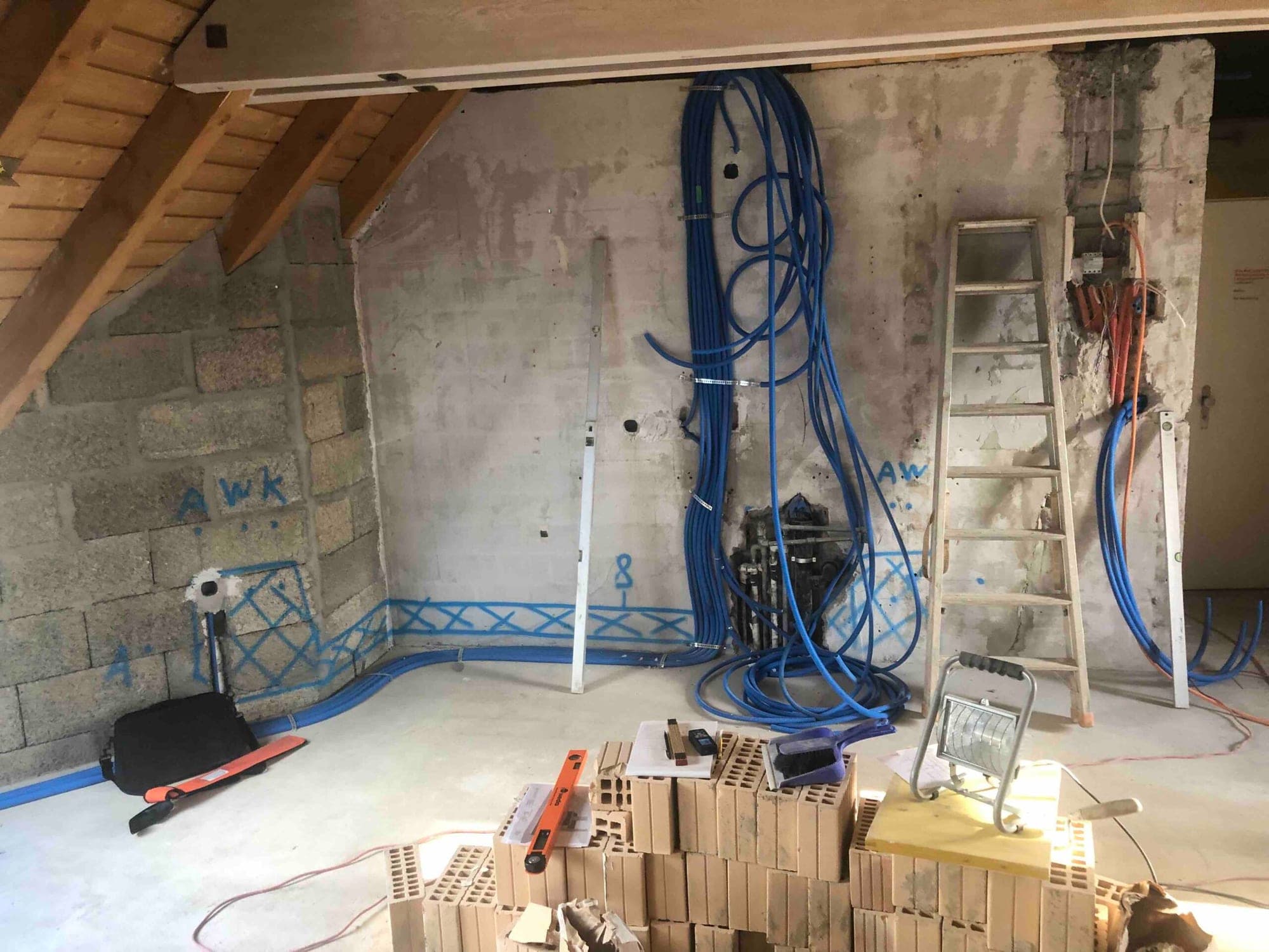 Dachwohnung in Zürich während des Umbaus: Elektro- und Wasserleitungen liegen offen in Wand und Boden, bevor die Küche montiert wird.