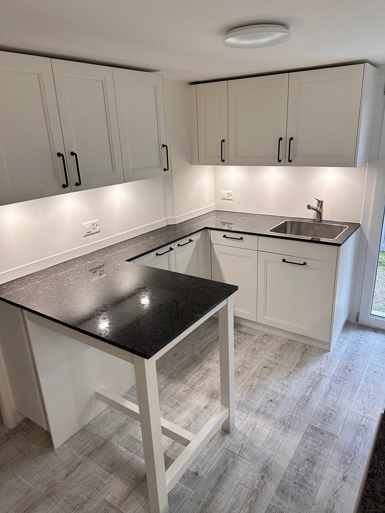 Helle Küche in U-Form mit Granit-Arbeitsplatte und Theke, Einfamilienhaus Müllheim